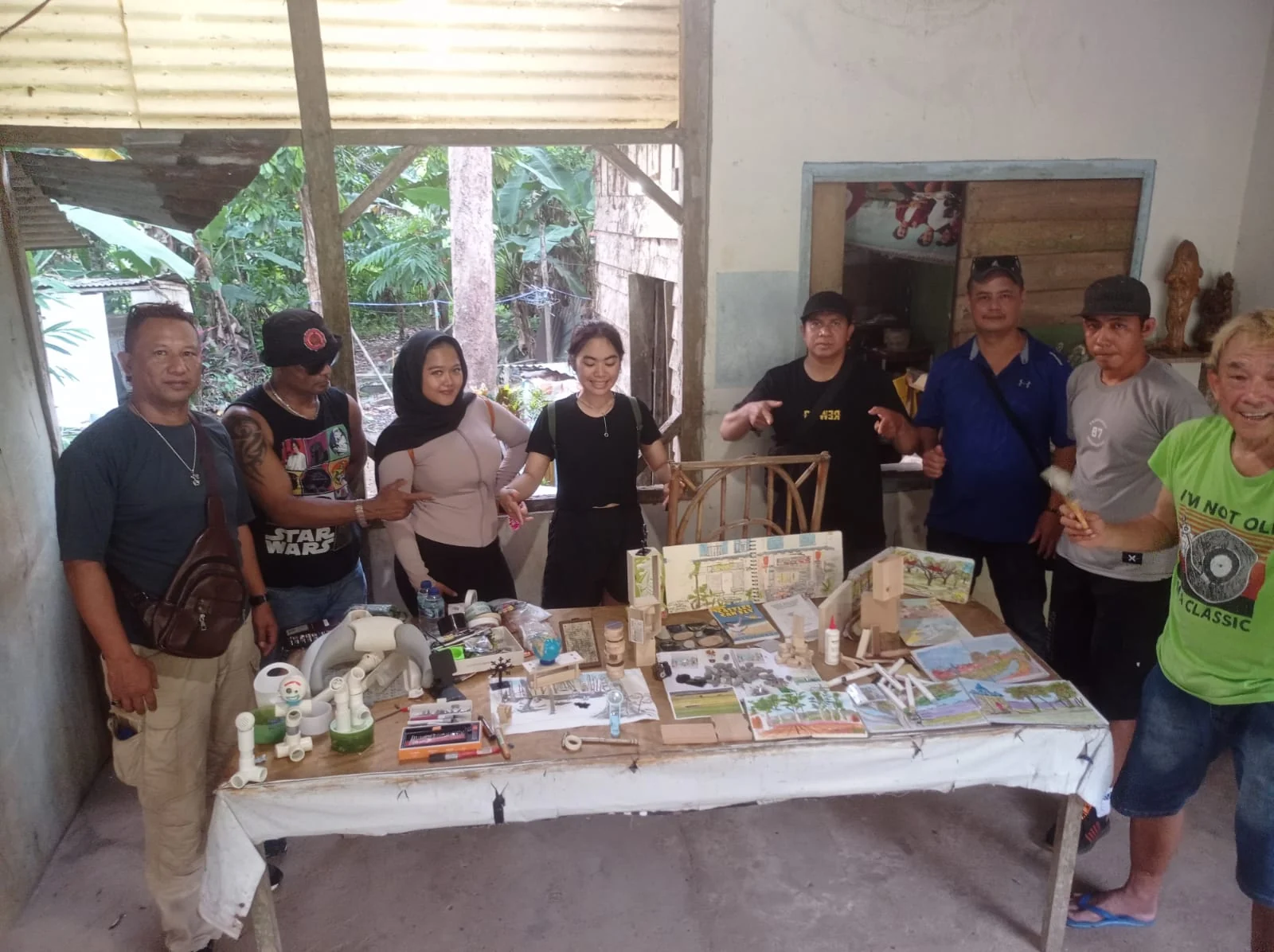 A group gathered around a table of artwork